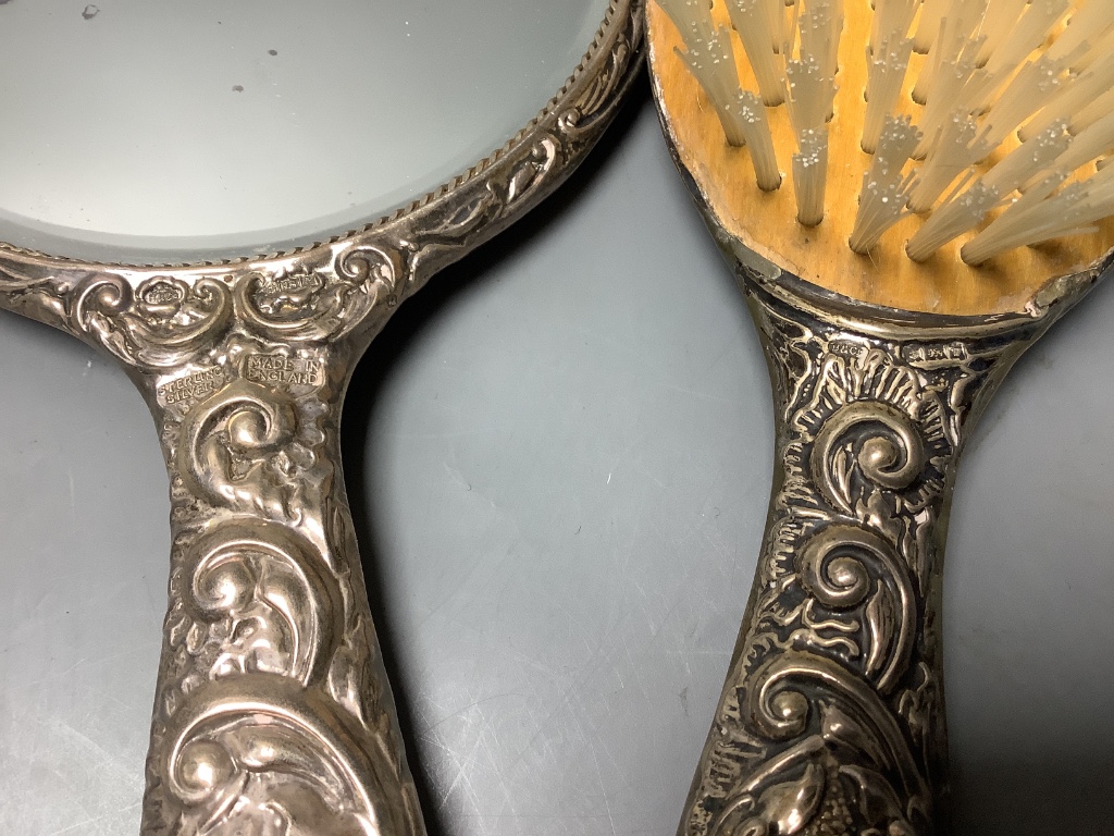 Two silver-topped narrow cylindrical toilet bottles, a silver backed-hand mirror and matching hairbrush, a comb and a silver compact